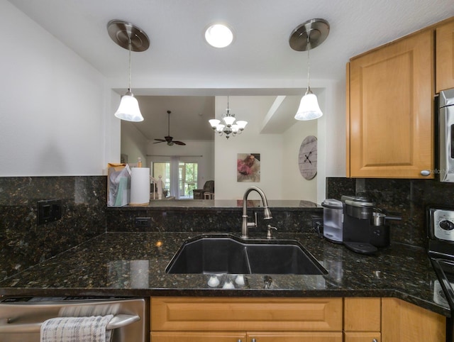 kitchen featuring dark stone countertops, sink, pendant lighting, and ceiling fan with notable chandelier