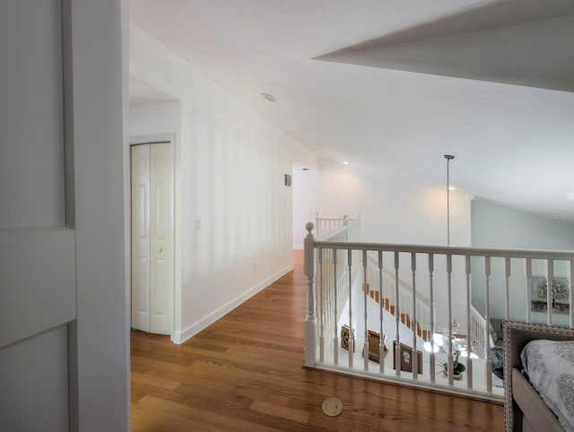 hall with hardwood / wood-style flooring and lofted ceiling