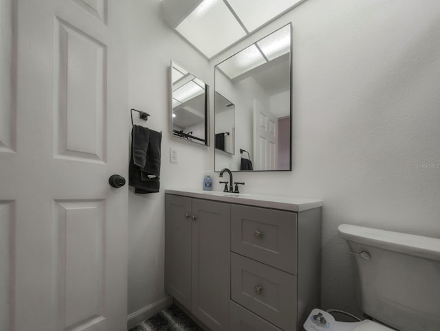 half bathroom with vanity and toilet