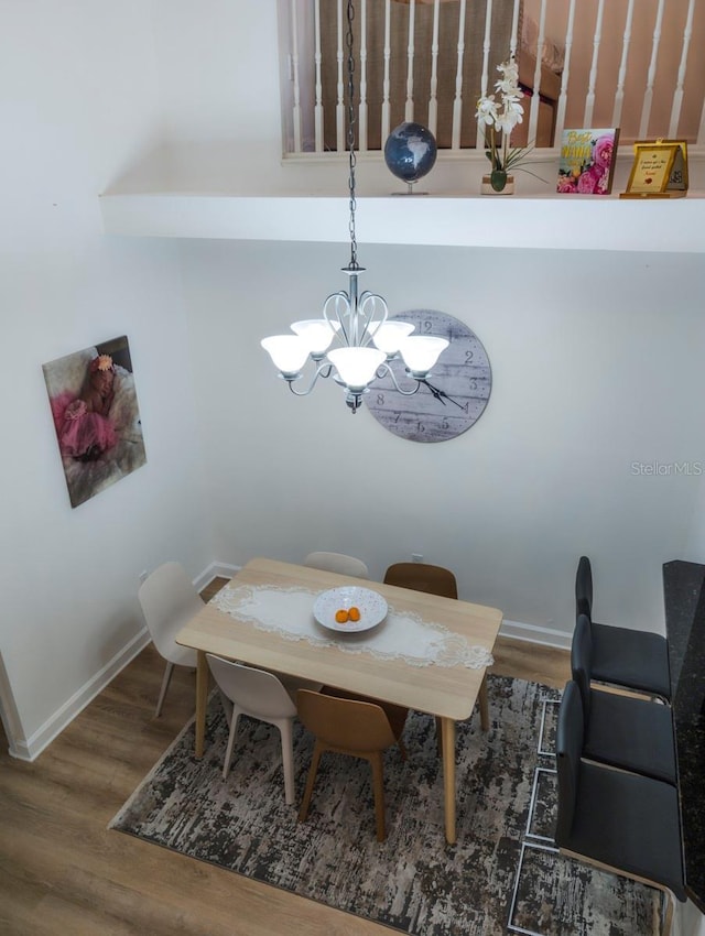 dining space with hardwood / wood-style flooring and a notable chandelier