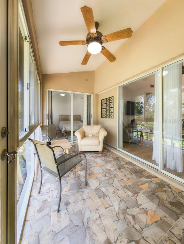 sunroom / solarium with ceiling fan and vaulted ceiling