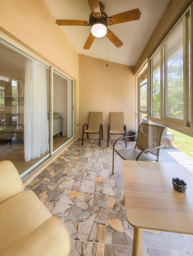 sunroom featuring lofted ceiling and a ceiling fan