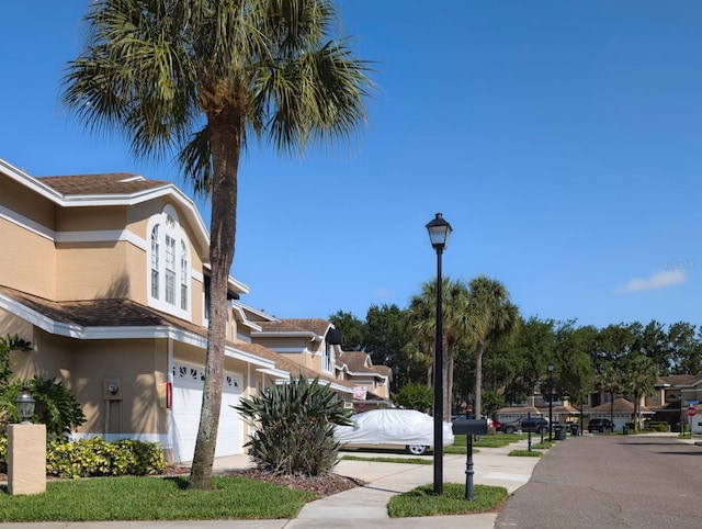 view of street featuring a residential view, sidewalks, and street lights