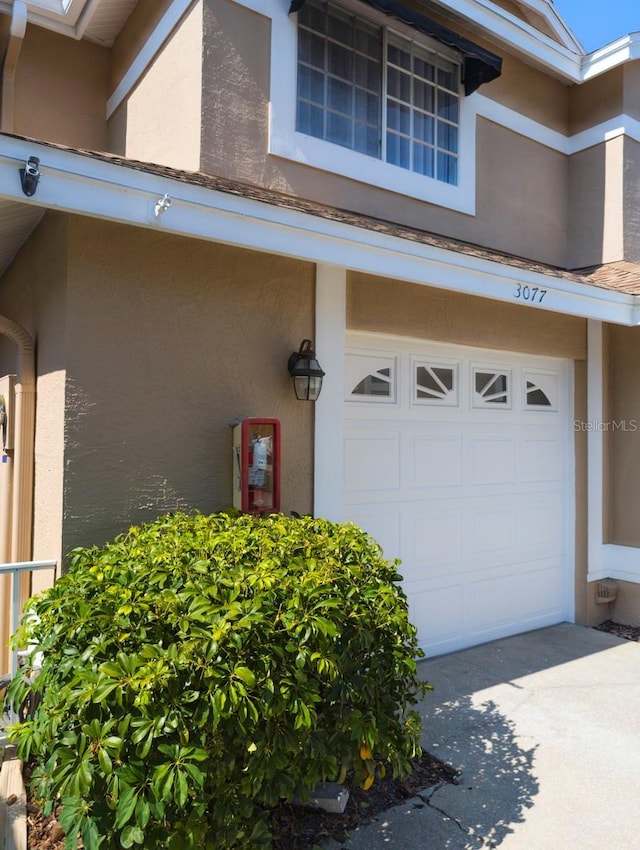 exterior space with concrete driveway and stucco siding