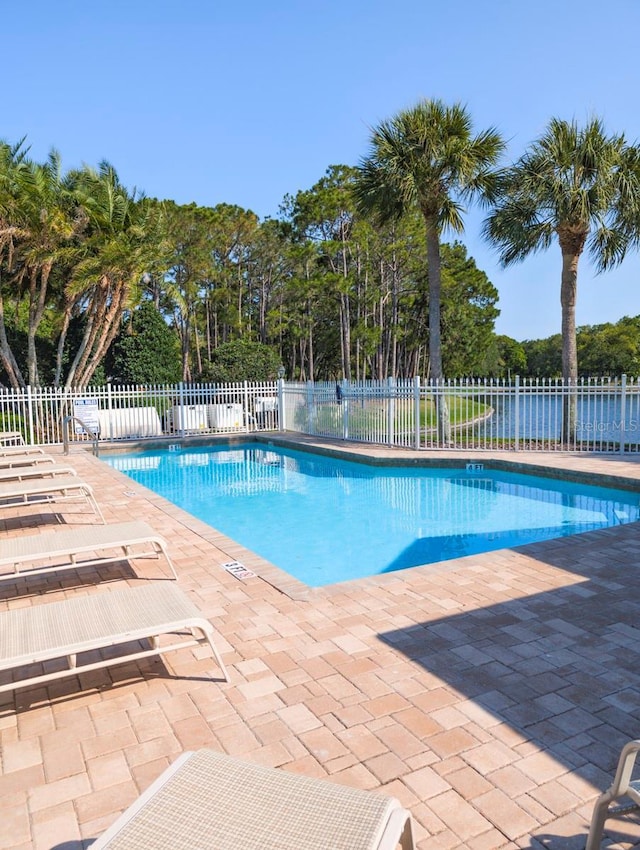 view of swimming pool with a patio area and a water view