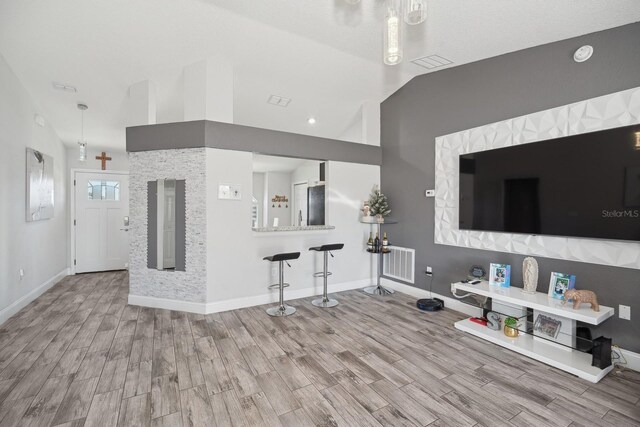 unfurnished living room with light hardwood / wood-style flooring and vaulted ceiling