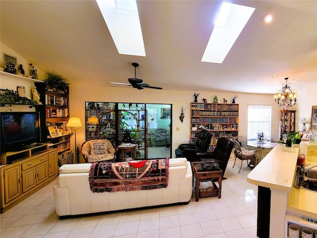 tiled living room with vaulted ceiling with skylight and ceiling fan with notable chandelier