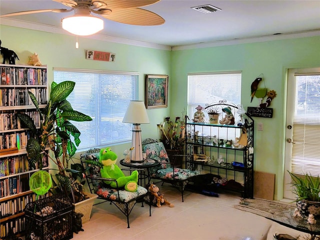 sitting room featuring ceiling fan, light tile patterned flooring, and crown molding