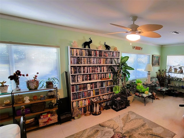 sitting room with ceiling fan, light tile patterned floors, and crown molding