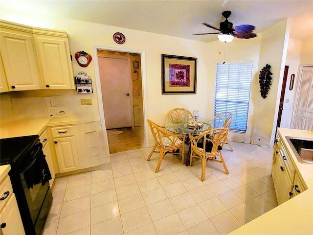 dining room featuring ceiling fan, light tile patterned floors, and sink