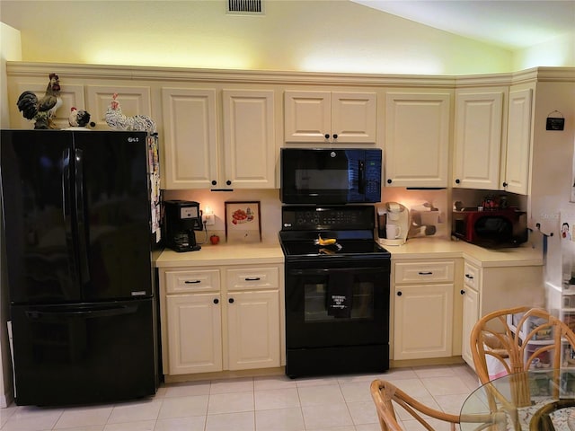 kitchen featuring light tile patterned flooring, black appliances, and lofted ceiling