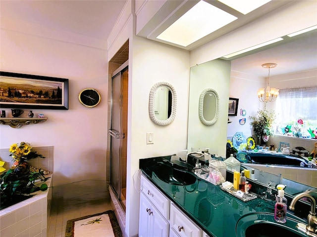 bathroom with ornamental molding, vanity, an inviting chandelier, and independent shower and bath