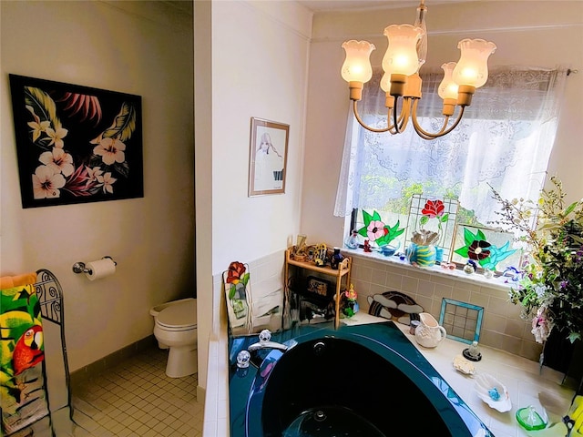 bathroom with toilet, a wealth of natural light, and a notable chandelier