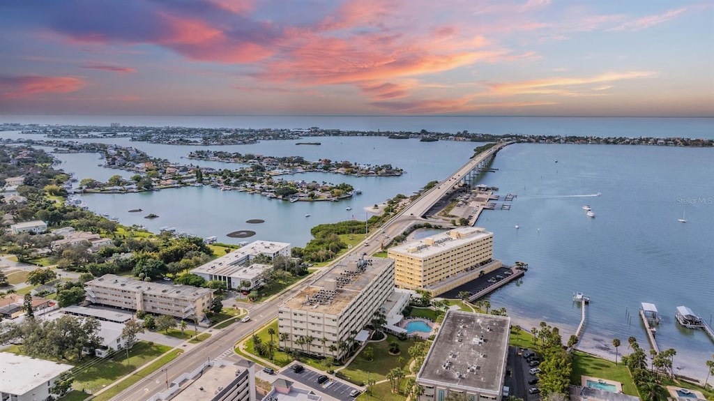 aerial view at dusk featuring a water view