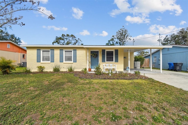 ranch-style home featuring a carport, cooling unit, and a front lawn