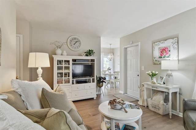 living room with a chandelier and light hardwood / wood-style flooring