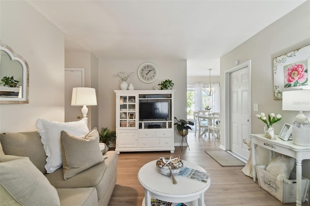 living room featuring a chandelier and wood-type flooring