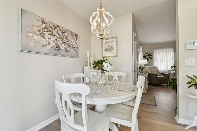 dining space with a notable chandelier and hardwood / wood-style flooring