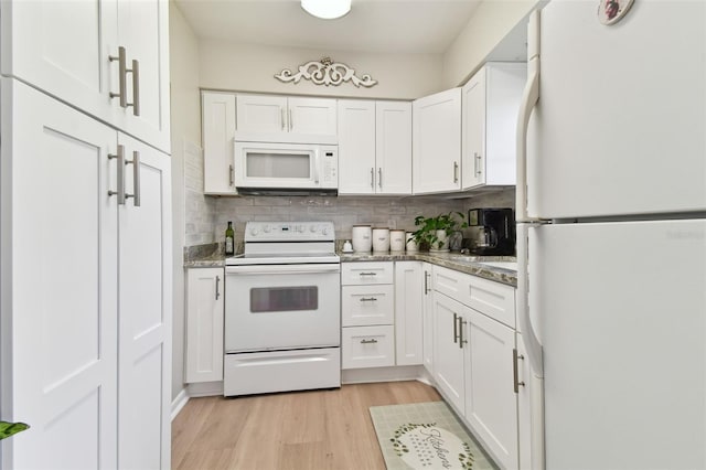 kitchen featuring white cabinetry, dark stone counters, light hardwood / wood-style floors, white appliances, and decorative backsplash