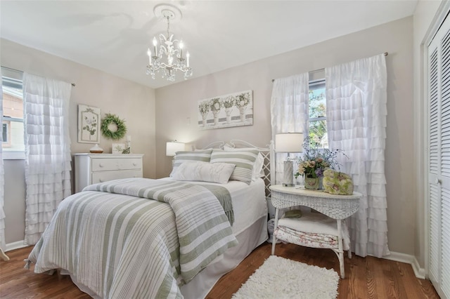 bedroom featuring a notable chandelier, dark hardwood / wood-style flooring, and a closet