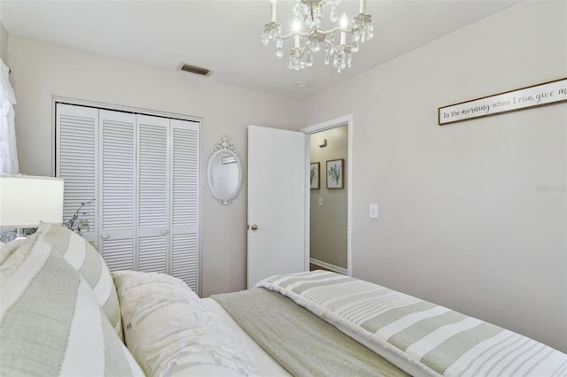 bedroom with an inviting chandelier and a closet