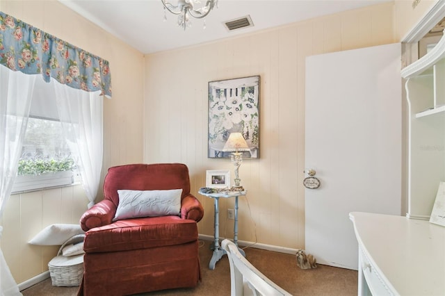 sitting room with carpet floors and an inviting chandelier