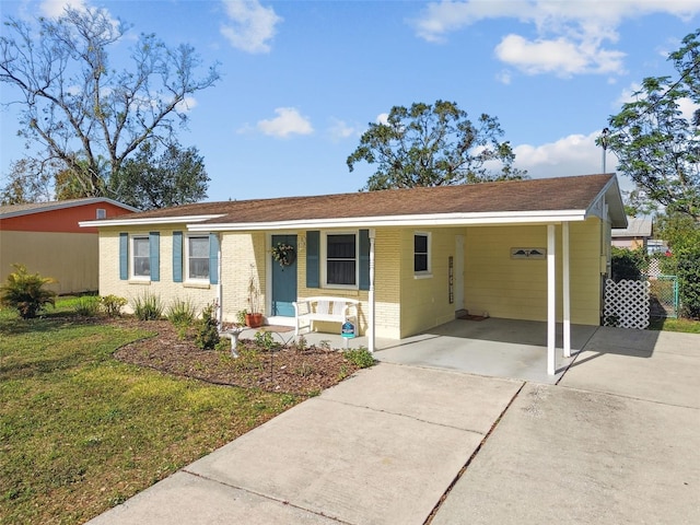 ranch-style house featuring a front lawn, a porch, and a carport