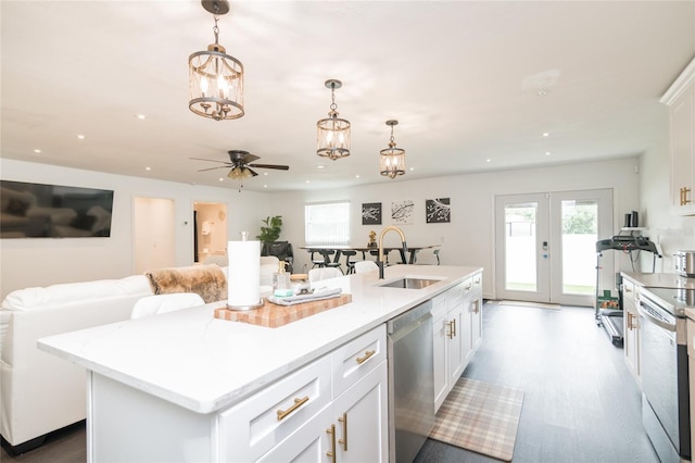 kitchen featuring a center island with sink, dishwasher, white cabinets, and sink