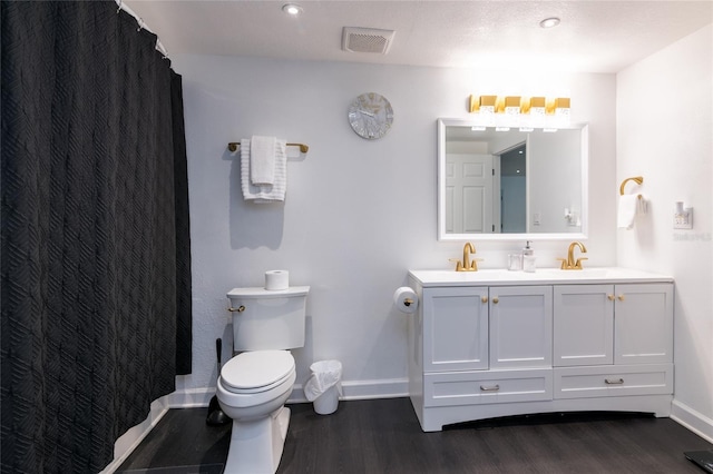 bathroom with a textured ceiling, vanity, hardwood / wood-style flooring, and toilet