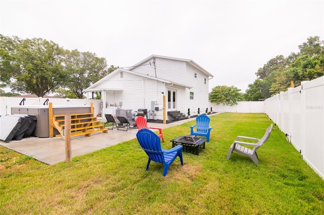 back of house with a yard, a patio, and a fire pit