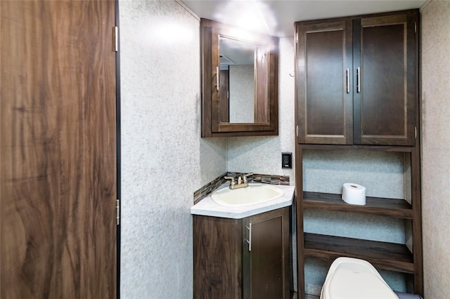 bathroom with backsplash, vanity, and toilet