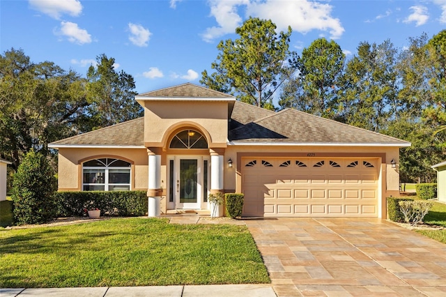 view of front of property with a garage and a front lawn