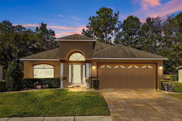 view of front of property with a yard and a garage