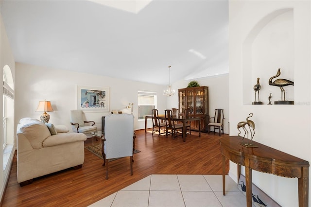 tiled living room with a notable chandelier and lofted ceiling