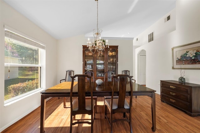 dining room with lofted ceiling, a chandelier, and light hardwood / wood-style flooring