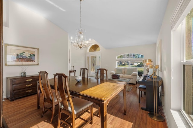 dining space with lofted ceiling, french doors, an inviting chandelier, and hardwood / wood-style floors