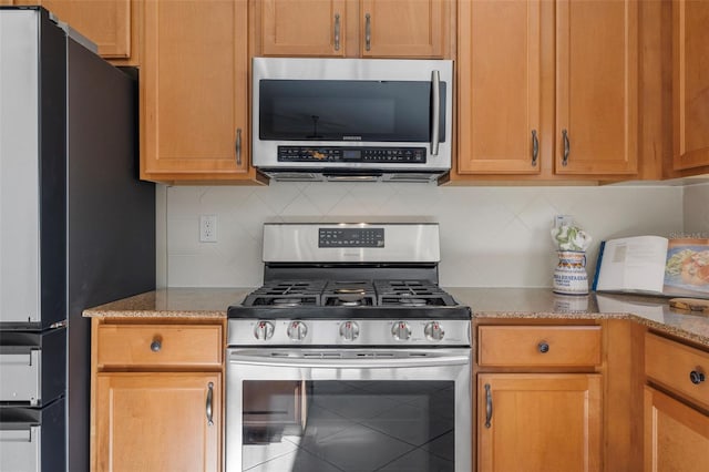 kitchen with stainless steel appliances and backsplash