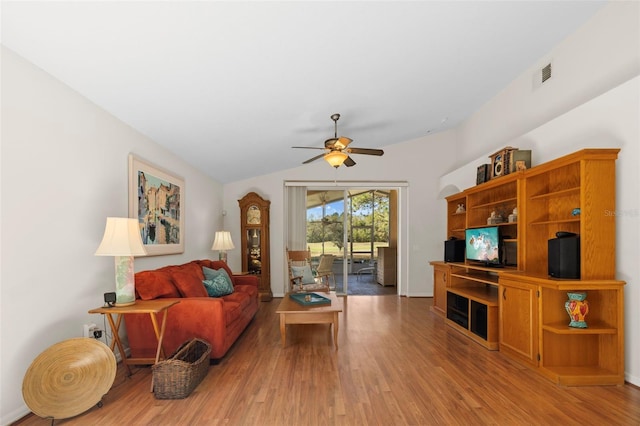 living room with ceiling fan, lofted ceiling, and hardwood / wood-style flooring