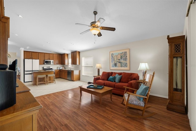 living room featuring lofted ceiling, sink, ceiling fan, and light hardwood / wood-style floors