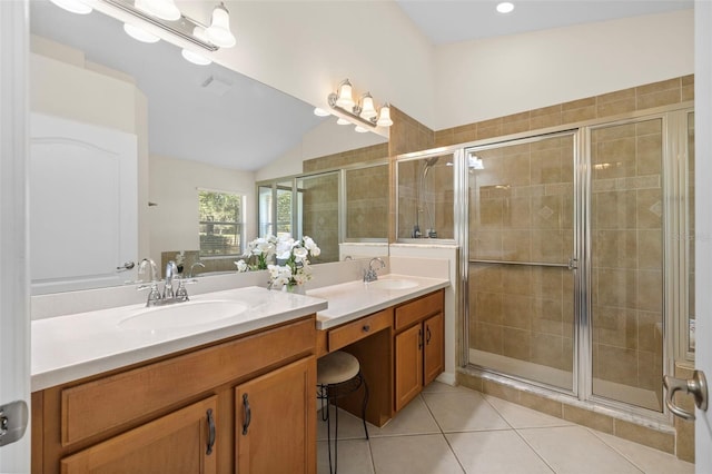 bathroom featuring a shower with shower door, vaulted ceiling, tile patterned floors, and vanity