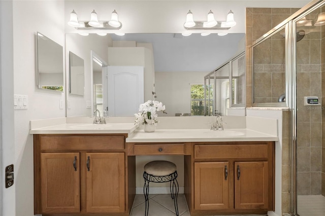 bathroom featuring a shower with door, vanity, and tile patterned floors