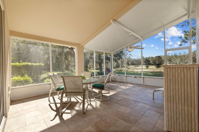 sunroom / solarium featuring vaulted ceiling, plenty of natural light, and ceiling fan