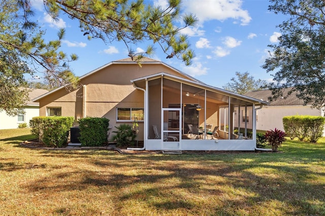 rear view of property with a yard, central AC, and a sunroom