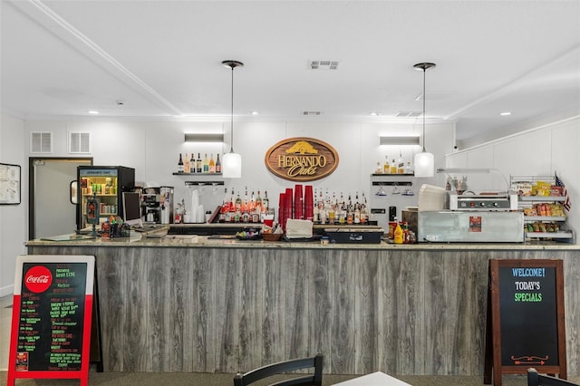 bar featuring crown molding and pendant lighting