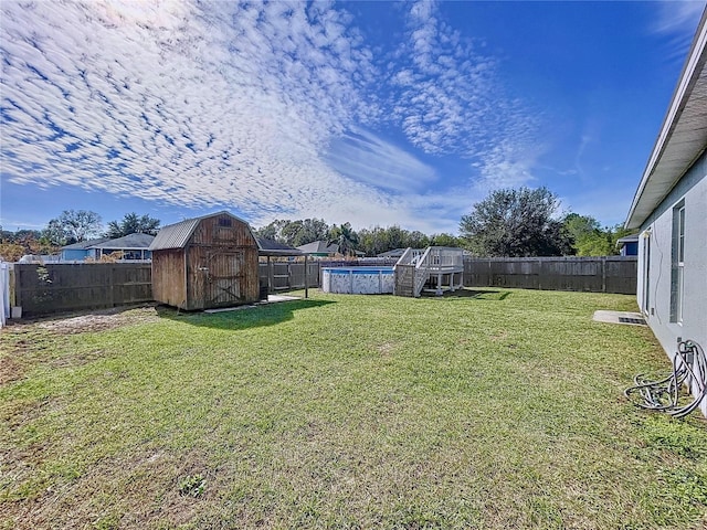 view of yard with a fenced in pool and a storage shed