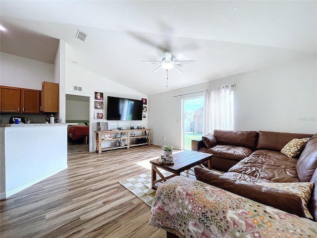 living room with ceiling fan, light hardwood / wood-style flooring, and lofted ceiling