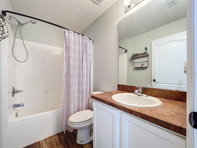 full bathroom with vanity, toilet, shower / bath combo with shower curtain, a textured ceiling, and wood-type flooring