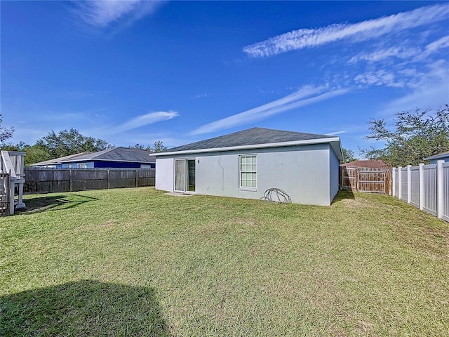 rear view of property featuring a lawn