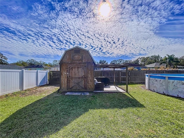 view of outbuilding with a lawn and a fenced in pool