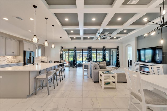 living room featuring visible vents, arched walkways, a ceiling fan, coffered ceiling, and marble finish floor